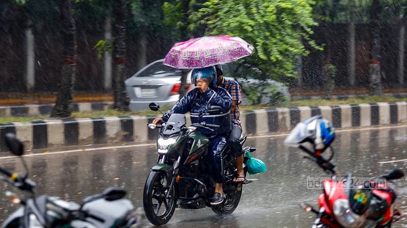 ঢাকার শহীদ ক্যাপ্টেন এম মনসুর আলী এভিনিউতে সোমবার দুপুরে বৃষ্টির মধ্যে ছাতা হাতে মোটর সাইকেলের যাত্রী।&amp;nbsp;ছবি: মাহমুদ জামান অভি