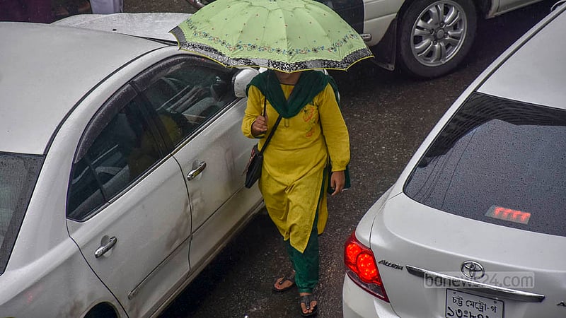 চট্টগ্রামের দামপাড়া এলাকায় বৃহস্পতিবার গুঁড়ি গুঁড়ি বৃষ্টির মধ্যে ছাতা মাথায় রাস্তা পার হচ্ছেন এক নারী।&amp;nbsp;ছবি: সুমন বাবু
