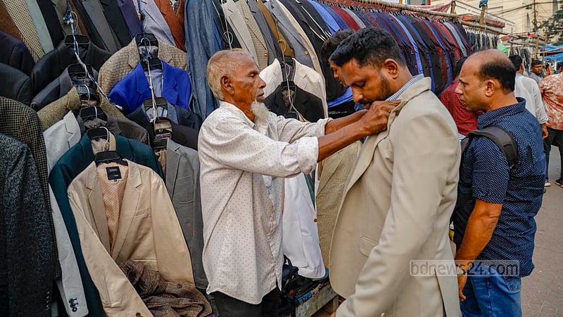 জিপিওর সামনে ফুটপাতে কোট পরে ট্রায়াল দিচ্ছেন এক ক্রেতা।