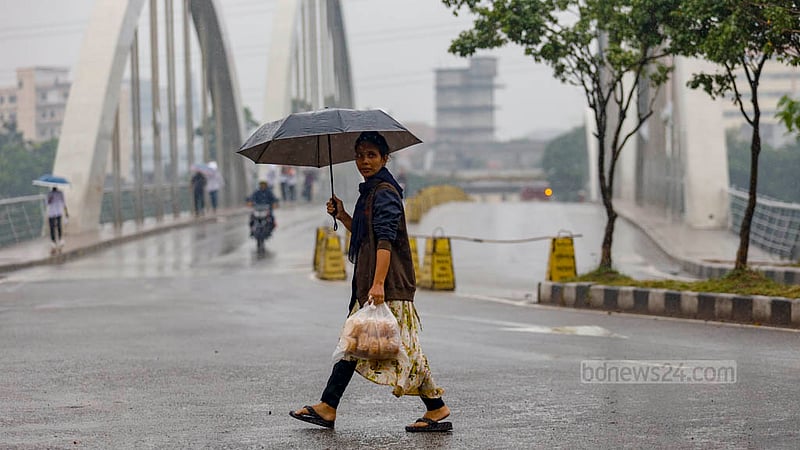 ঢাকার হাতিরঝিল এলাকায় বৃহস্পতিবার দুপুরে বৃষ্টিতে ছাতা মাথায় চলেন অনেকেই।