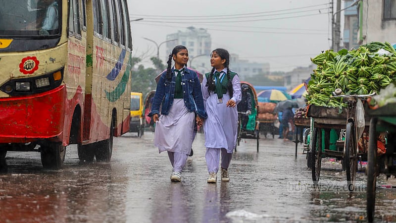 ঢাকার মোহাম্মদপুর বাসস্ট্যান্ড এলাকায় বৃহস্পতিবার দুপুরে অসময়ের বৃষ্টিতে ভিজতে দেখা যায় দুই শিক্ষার্থীকে।