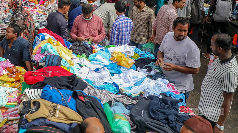 ঢাকার গুলিস্তানে সড়কের উপর হকাররা বসেছেন শীতের কাপড়ের অস্থায়ী দোকান নিয়ে।