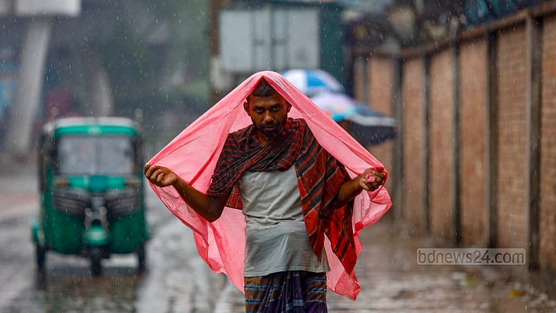 ঢাকার হাতিরঝিল এলাকায় বৃহস্পতিবার দুপুরে বৃষ্টিতে পলিথিন মাথায় একজন।