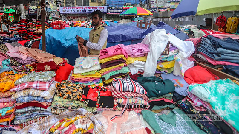 ঢাকার মোহাম্মদপুরে কৃষি মার্কেটের দোকানিরা চকিতে কাপড়ের পসরা সাজিয়ে রেখেছেন।