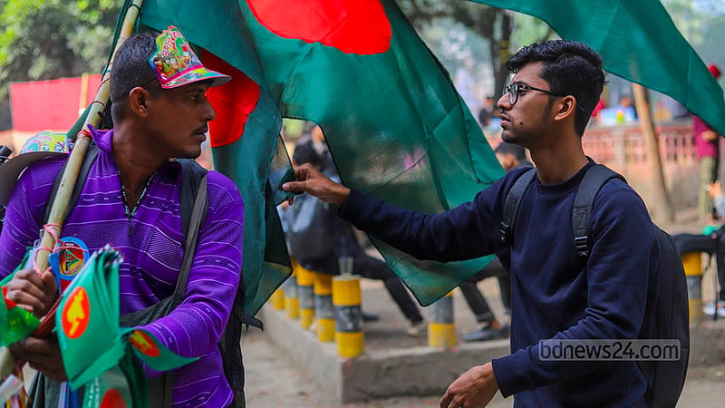 ঢাকা বিশ্ববিদ্যালয় এলাকায় ভ্রাম্যমাণ এক বিক্রেতার কাছে জাতীয় পতাকা দেখছেন এ শিক্ষার্থী।