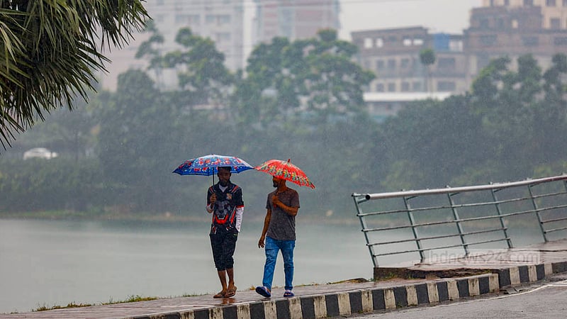 ঢাকার হাতিরঝিল এলাকায় বৃহস্পতিবার দুপুরে বৃষ্টিতে ছাতা মাথায় চলেন অনেকেই।
