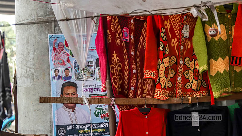 ফার্মগেট এলাকায় মেট্রোরেলের পিলারে ঝুলছে শীতের পোশাক।