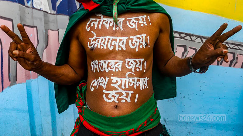 দ্বাদশ জাতীয় সংসদ নির্বাচনে আওয়ামী লীগের বিজয়ের কথা শরীরে লিখে সোহরাওয়ার্দীর সমাবেশে আসেন এক কর্মী।