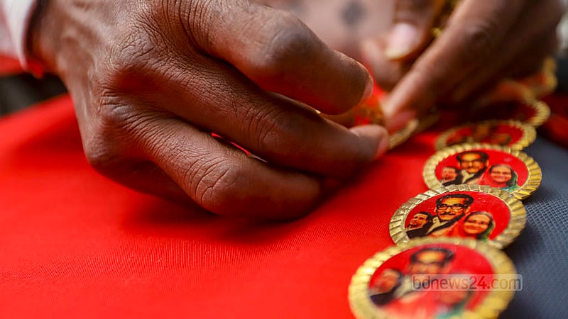 আওয়ামী লীগ আয়োজিত সমাবেশে উপলক্ষে ঢাকা বিশ্ববিদ্যালয়ের টিএসসি এলাকায় বুধবার সকালে স্মারক ব্যাজ বিক্রি করছেন এক বিক্রেতা।