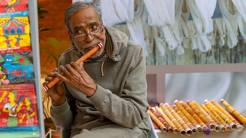 খাদি উৎসবে ‘বাঁশের বাঁশি’ নামে একটি স্টলে বসে শনিবার বিকালে আপনমনে বাঁশি বাজাচ্ছিলেন শিল্পী কমল।