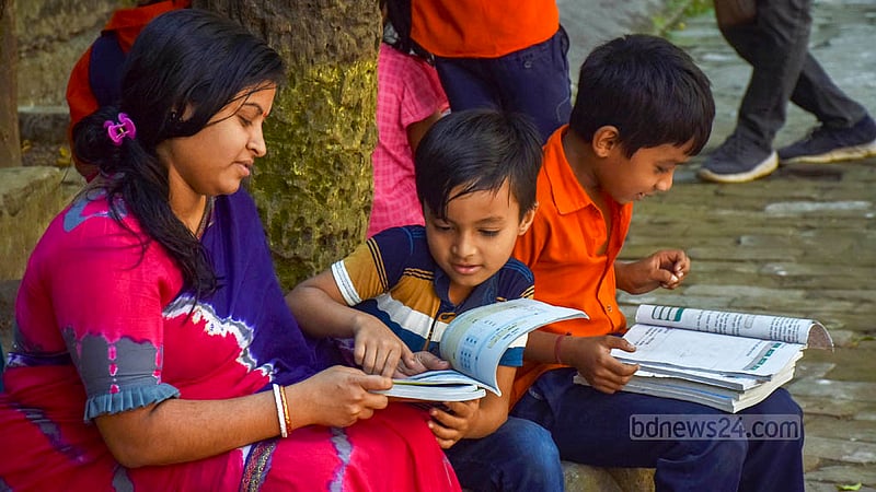নতুন বছরে নতুন বই পেয়ে চট্টগ্রাম সরকারী ন্যাশনাল প্রাইমারি স্কুল মাঠে মা-ছেলের আনন্দ- উচ্ছ্বাস।