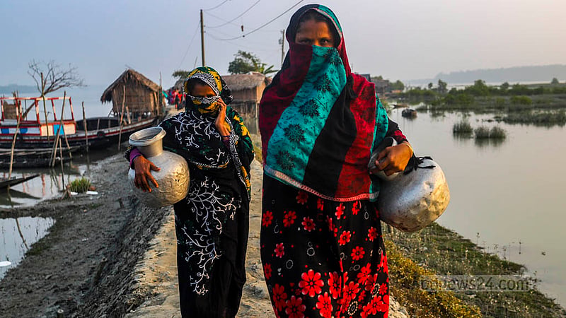 দাকোপের কালাবগি এলাকার ঝুলন্ত পাড়ার নারীরা খাওয়ার পানি আনতে কলসি নিয়ে পুকুরে যাচ্ছেন। বর্ষার মজুদ করা পানি ফুরিয়ে গেলে দূর থেকে আনা পুকুরের সুপেয় পানিই ভরসা তাদের।