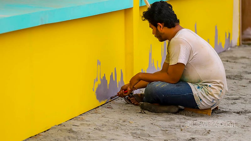 ঢাকার সোহরাওয়ার্দী উদ্যানে একুশে বইমেলার দুয়ার খুলার আগ মুহূর্তে স্টলে চলছে রঙের কাজ।