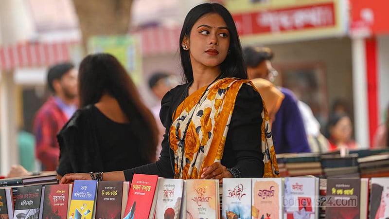 একুশে বইমেলায় বুধবার স্টলের বিক্রেতারাও ছিলেন বাসন্তী সাজে। কেউ লাল তো, কেউ বাসন্তী আবার কেউবা মেরুন বা সাদা রঙের শাড়িতে সেজে এসেছিলেন মেলায়।