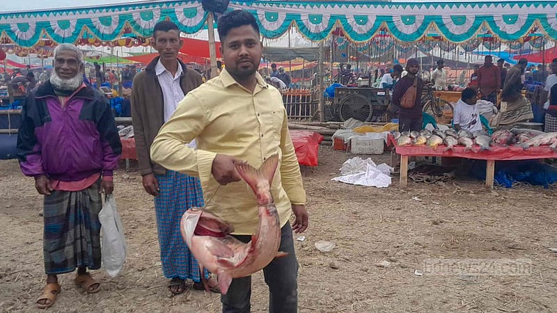 পোহাদহ মেলা থেকে মাছ কিনে মনের আনন্দে ফিরছেন এই ব্যক্তি।