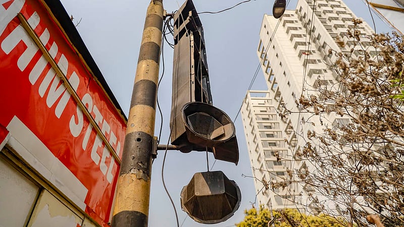 ঢাকার কাকরাইলে পুলিশ বক্সের পেছনে ট্রাফিক সিগনালের কাঠামোতে ঝুলছে খুলে যাওয়া বাতি। দেখার কেউ নেই।