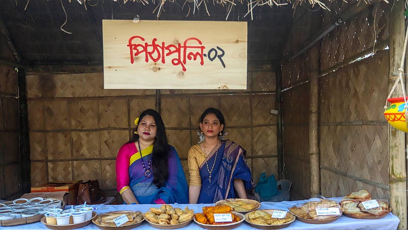বাংলাদেশ শিল্পকলা একাডেমিতে জাতীয় পিঠা উৎসবের একটি স্টলে শনিবার পিঠার পসরা সাজিয়েছেন নারী বিক্রেতারা।