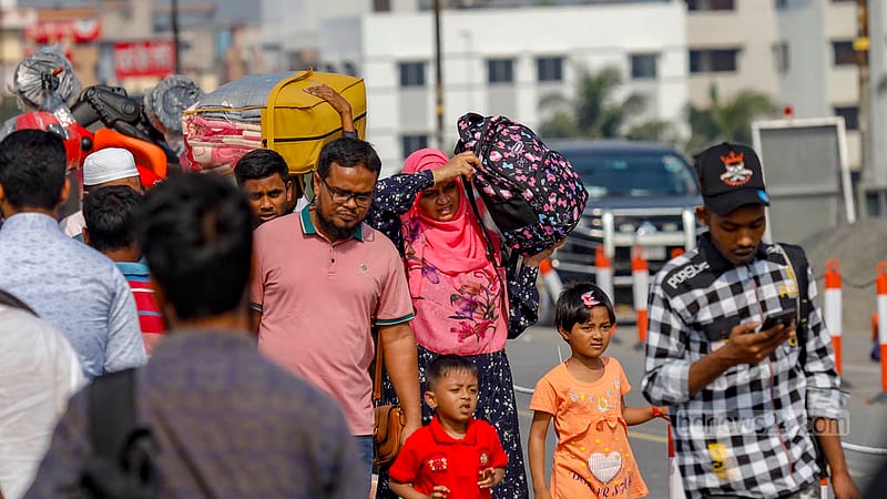 পোস্তগোলা সেতু দিয়ে সোমবার দুপুরে মাথায় ব্যাগ নিয়ে হেঁটে পার হচ্ছেন এক নারী।