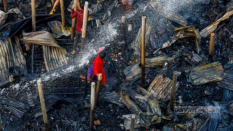 আগুন কিছুটা নিভেছে, ফায়ার সার্ভিসের সদস্যরা কাজ চালিয়ে যাচ্ছেন; তার মধ্যেই পুড়ে যাওয়া ঘরের দিকে ছুটছেন এক নারী।