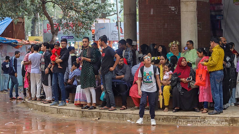 অমর একুশে বইমেলায় বৃহস্পতিবার বিকালে বৃষ্টি শুরু হলে দর্শনার্থীরা নিরাপদ স্থানে আশ্রয় খোঁজেন।