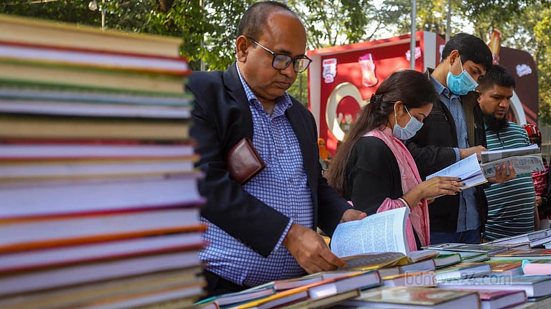 একুশে বইমেলার তৃতীয় দিন শনিবার বিকালে একটি স্টলে বই দেখছেন দর্শনার্থীরা।
