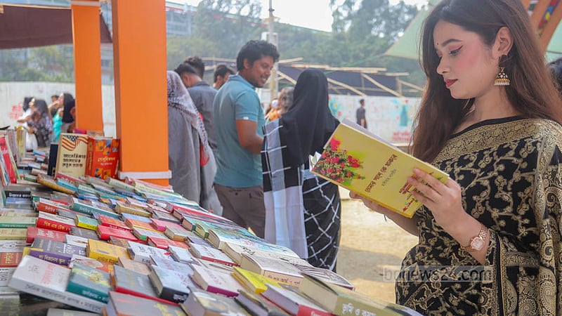 বইমেলায় সোহরাওয়ার্দী উদ্যান অংশে বুধবার বই দেখছেন এ তরুণী।