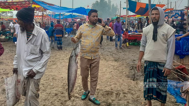 পোহাদহ মেলা থেকে মাছ কিনে মনের আনন্দে ফিরছেন এই ব্যক্তি।