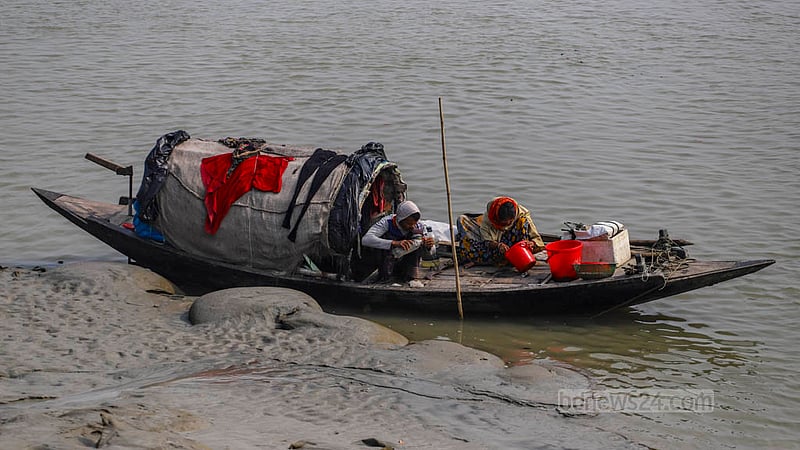 দাকোপের সুতারখালী নদীতে নৌকার উপর রেণু বাছাই করছেন এক নারী।