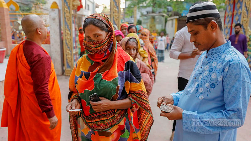 বাসাবোর ধর্মরাজিক বৌদ্ধ বিহারে শুক্রবার ইফতারি নেওয়ার আগে লাইনে দাঁড়িয়ে থাকা মানুষদের দেওয়া হয় টোকেন।