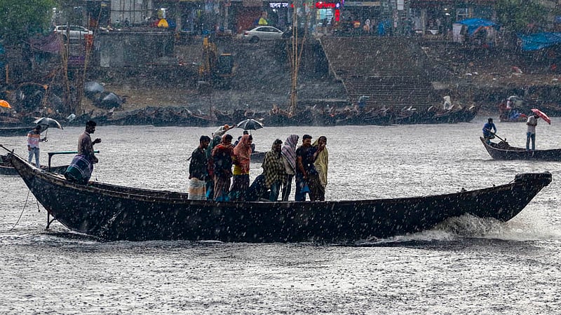 চৈত্রের শুরুতেই মঙ্গলবার বিকালে বৃষ্টি মাথায় বুড়িগঙ্গা নদী খেয়া দিয়ে পাড়ি দেন অনেকেই।