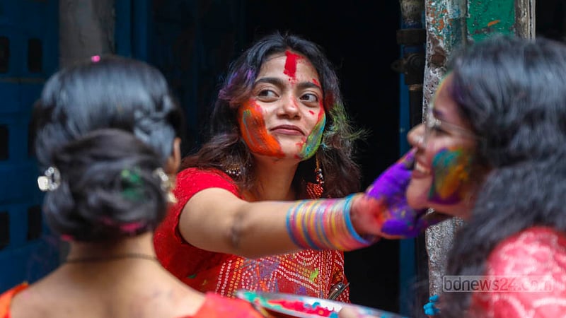 পুরান ঢাকার শাঁখারীবাজারে সোমবার দুপুরে আবির খেলছে দুই তরুণী।