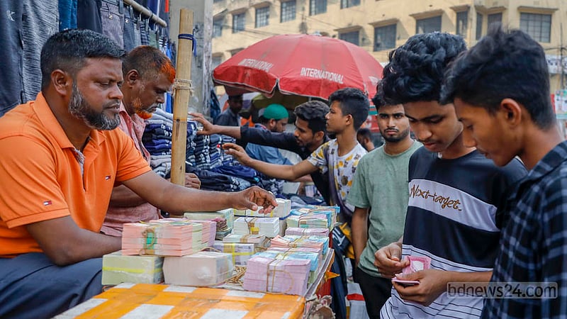 ঢাকার গুলিস্তান শপিং কমপ্লেক্সের সামনে নতুন টাকার দোকানে শনিবার দুপুরে টাকা গুনছেন এক ক্রেতা।
