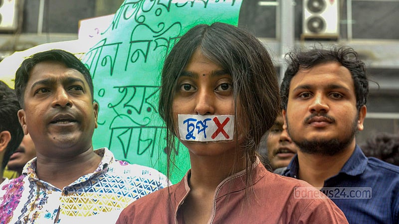 বিশ্ববিদ্যালেয়ে যৌন নিপীড়নের প্রতিবাদে সোমবার মুখ স্কচটেপে আটকে এক শিক্ষার্থী।&amp;nbsp; 