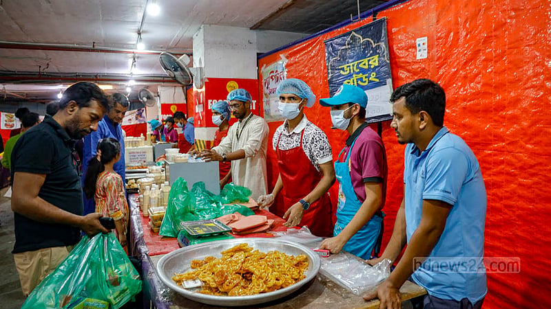 বেইলি রোডের ক্যাপিটাল সিরাজ সেন্টারের বেইজমেন্টের ‘ক্যাপিটাল ইফতার বাজার’ থেকে ইফতারি কিনছেন ক্রেতারা।