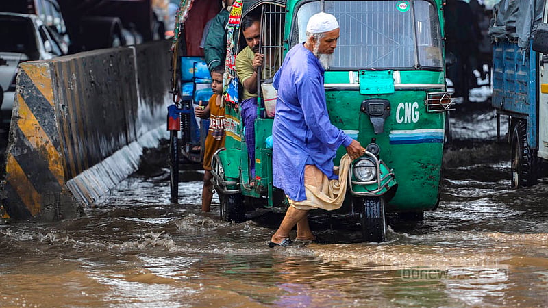 ঢাকার পোস্তগোলা এলাকায় বৃহস্পতিবার জলাবদ্ধতা সৃষ্টি হলে দুর্ভোগে পড়েন সিএনজিচালিত অটোরিকশার চালকরা। পানির কারণে ইঞ্জিন বন্ধ হয়ে যাওয়ায় ঠেলে গাড়ি নিয়ে যাচ্ছেন একজন।