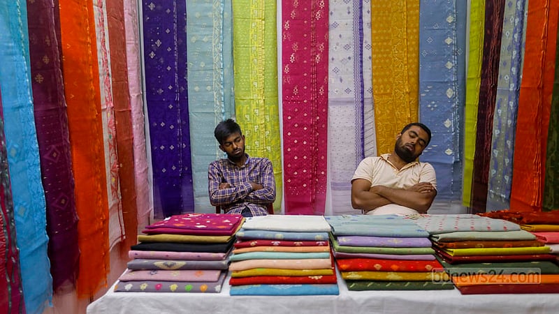 জাতীয় জাদুঘরের নলিনীকান্ত ভট্টশালী আর্ট গ্যালারিতে বুধবার জামদানি মেলার শেষ দিন ক্রেতা কম থাকায় একটি স্টলের কর্মীদের আলস্যে সময় কাটাতে দেখা যায়।