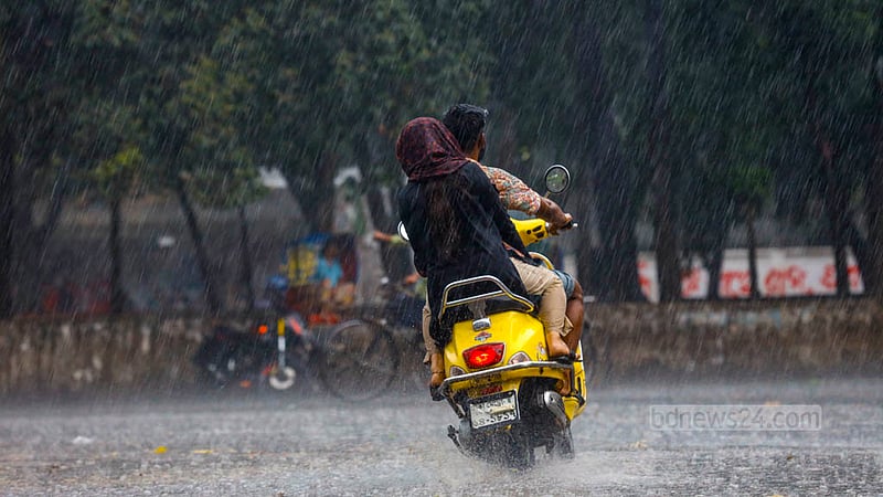 ঢাকা বিশ্ববিদ্যালয় এলাকায় মঙ্গলবার বিকালে ঝুম বৃষ্টি উপভোগ করছেন মোটরসাইকেলের দুই আরোহী।