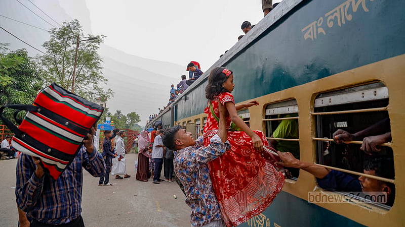 জয়দেবপুর রেলওয়ে স্টেশন মঙ্গলবার বিকালে জামালপুরের ট্রেনের ছাদে এক শিশুকে ওঠানোর চেষ্টা করছেন তার পরিবারের সদস্যরা।