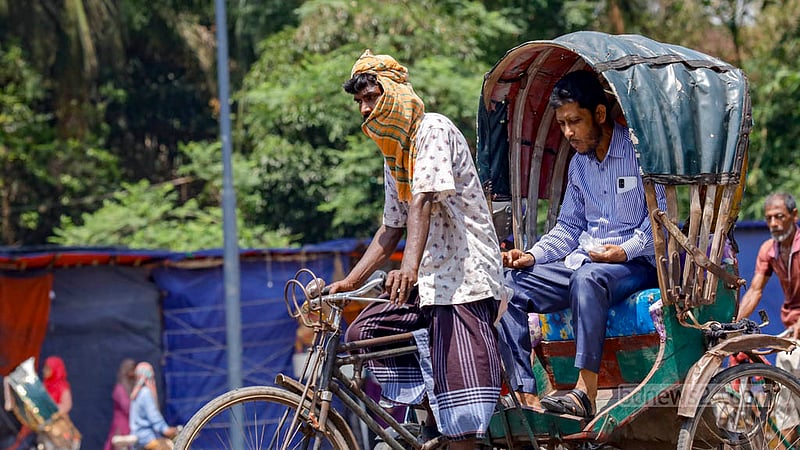 ঢাকা বিশ্ববিদ্যালয়ের দোয়েল চত্বর এলাকায় শনিবার দুপুরে তীব্র রোদ থেকে কিছুটা নিস্তার পেতে গামছা মাথায় এক রিকশাচালক।