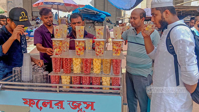 ঢাকার গুলিস্তান এলাকায় সোমবার দুপুরে সড়কের পাশে নানা রকম ফল দিয়ে তৈরি শরবত খাচ্ছেন পথচারীরা।