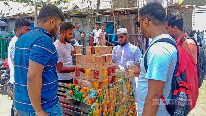 ঢাকার গুলিস্তান এলাকায় সোমবার দুপুরে সড়কের পাশে নানা রকম ফল দিয়ে তৈরি শরবত খাচ্ছেন পথচারীরা।