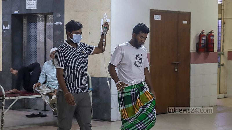 রাজধানীর মুগদা মেডিকেল কলেজ হাসপাতালে চিকিৎসাধীন ডেঙ্গু আক্রান্ত একজনকে ধরে নিয়ে যাওয়া হচ্ছে টয়লেটে। তিনি এই হাসপাতালে চিকিৎসাধীন ৩ দিন ধরে