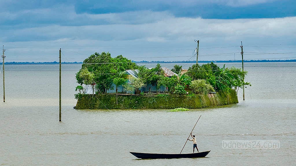 বিপুল জলরাশির মধ্যে ছোট্ট ডিঙ্গি বেয়ে চলছেন এক ব্যক্তি, পেছনে সবুজে ঘেরা দ্বীপের মধ্যে একটি ঘর। অষ্টগ্রামের বড় হওরের এমন দৃশ্য শুধু বর্ষাতেই দেখা যায়