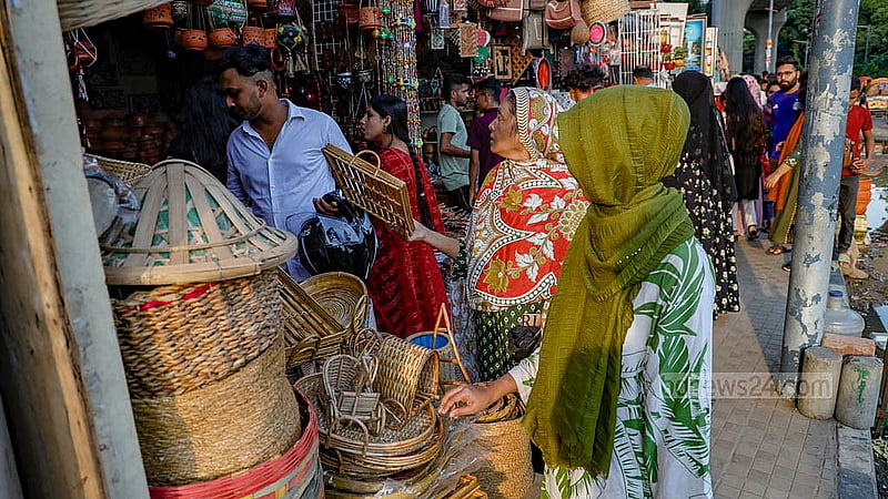 ঢাকা বিশ্ববিদ্যালয়ের দোয়েল চত্বরের পাশে ফুটপাতের একটি দোকানে বাঁশ ও বেতের তৈরি তৈজসপত্র দেখছেন এক নারী
