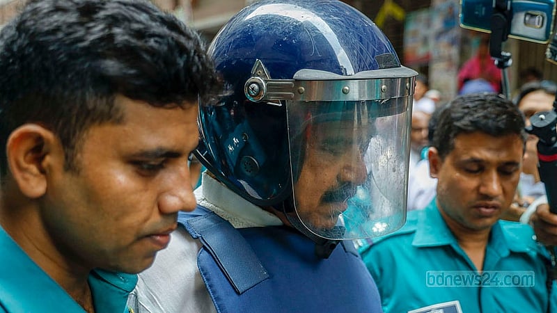 সাবেক নৌপরিবহন মন্ত্রী শাজাহান খানকে বুধবার আদালতে নেওয়ার সময় তাকে হাসতে দেখা যায়
