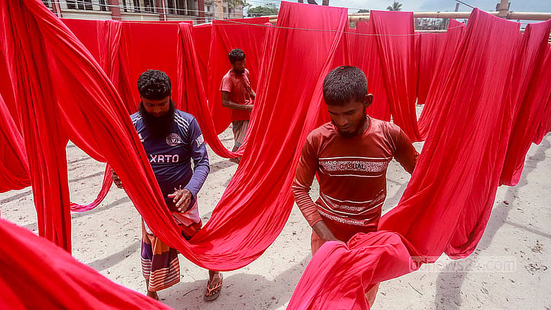 নারায়ণগঞ্জের ফতুল্লার হাজীগঞ্জ এলাকায় ডাইং কারখানায় রং করা কাপড় শুকানোর কাজে ব্যস্ত শ্রমিকরা