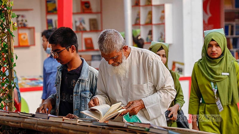 অমর একুশে বইমেলার একটি স্টলে বই দেখছেন এক ব্যক্তি