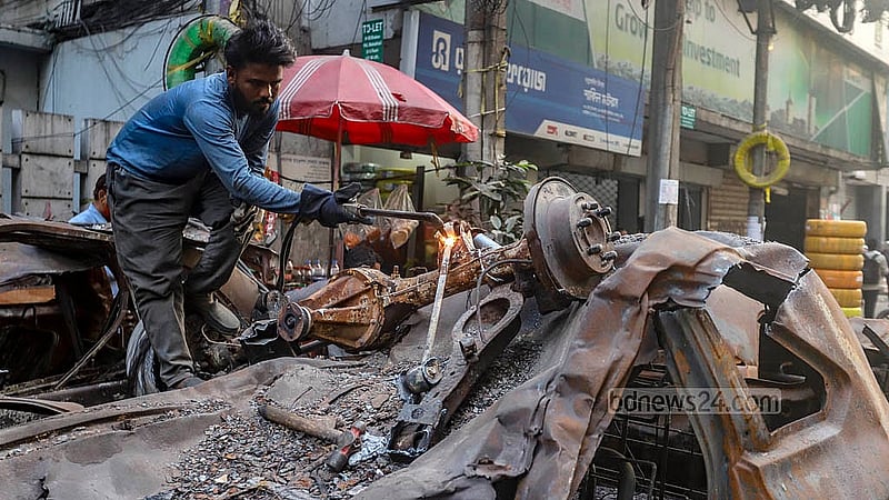 মহাখালীতে দুর্যোগ ব্যবস্থাপনা ভবনের সামনে ফেলে রাখা পুড়ে যাওয়া গাড়ি গ্যাস কাটারের মাধ্যমে কাটা হচ্ছে। পাঁচ মাস পর এসব গাড়ি সরিয়ে নেওয়ার কাজ শুরু হয়েছে