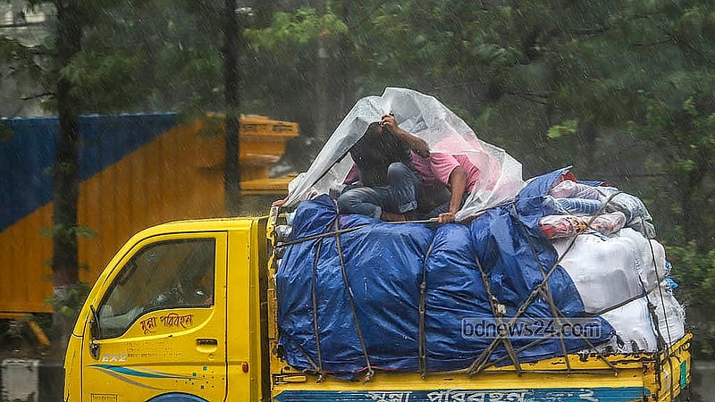 পিকআপে মালামালের ওপর বসে থাকা কয়েকজন মাথায় পলিথিন দিয়ে বৃষ্টি থেকে রক্ষা পাওয়ার চেষ্টা করেন। বুধবার ডিএমপি কার্যালয়ের সামনে থেকে তোলা
