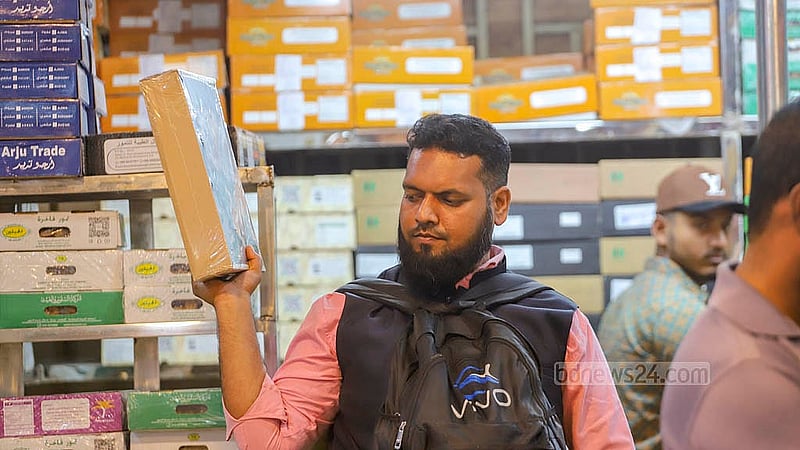 পুরান ঢাকার বাদামতলি পাইকারি আড়ত থেকে খুচরায় খেজুর কিনছেন অনেকেই। স্থানীয় বাজারের খেজুরের দাম বেশি হওয়ায় বাদামতলিতে আসেন অনেক ক্রেতা